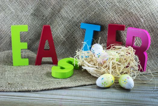 easter with letters on wooden table and jute background