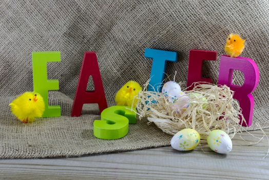 easter with letters on wooden table and jute background