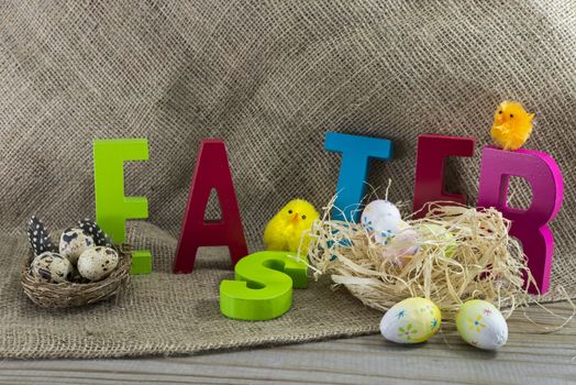 easter with letters on wooden table and jute background