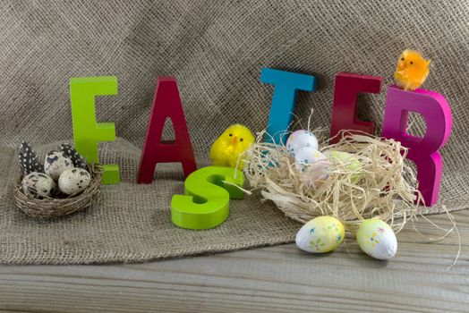 easter with letters on wooden table and jute background