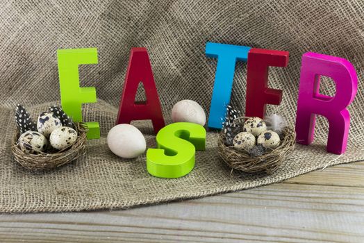 easter with letters on wooden table and jute background