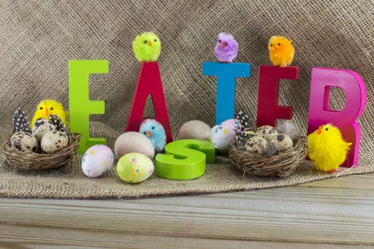easter with letters on wooden table and jute background