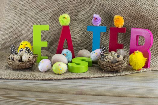 easter with letters on wooden table and jute background
