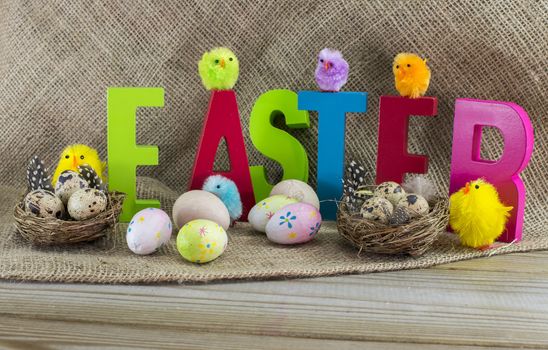 easter with letters on wooden table and jute background