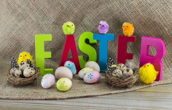 easter with letters on wooden table and jute background