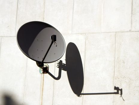 Grey antenna outside on a white wall