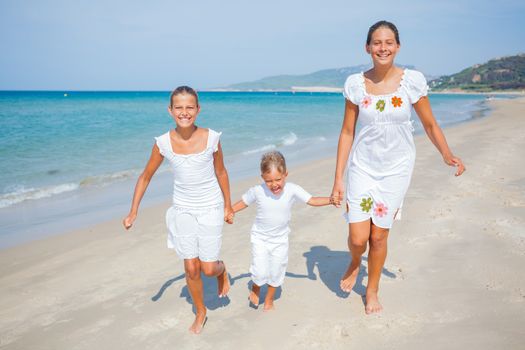 Adorable happy boy and girls running on beach vacation