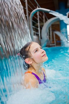 Activities on the pool. Cute girl swimming and playing in water in thermal hot pool