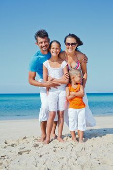 Family of four having fun on tropical beach