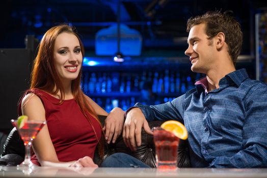 Young couple talking in a nightclub, have fun