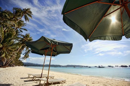 Sun umbrella with chair longues on tropical beach, Philippines, Boracay