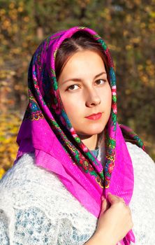 Portrait of a Russian girl in a scarf on a sunny autumn day
