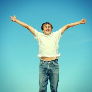 Toned photo of Happy Teenager jumping on the Blue Sky Background