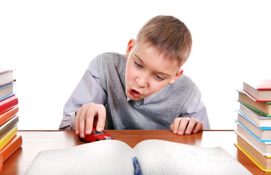 Schoolboy plays with a Toy on the School Desk on the white background