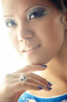 Beautiful Asian lady with perfect makeup and jewelry on a white background