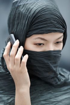 Muslim lady in hijab talking via cell phone