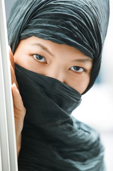 Oriental lady in black hijab hiding