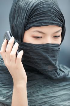 Muslim lady in hijab talking via cell phone