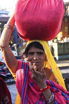 Indian woman carrying bundle on her head, Bundi, Rajasthan, India