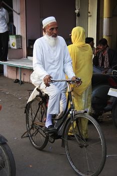 Indian man riding bicycle in the narrow streets of old town, Bundi, Rajasthan, India