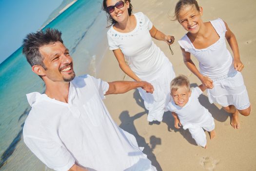 Photo of happy family running on the beach