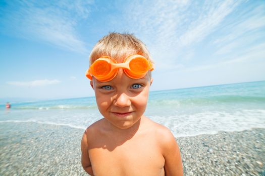 Playful boy on the beach with sea on background