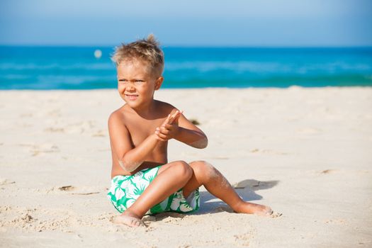 playful boy on the beach with sea on background