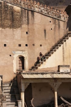 Young woman sitting on the stairs, Bundi Palace, Rajasthan, India