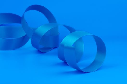 Blue Curly Silk Ribbon isolated on Blue background