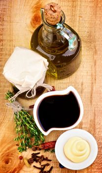 Ingredient for Cooking Salad Sauce with Olive Oil, Spices, Herbs and Mayonnaise closeup on Wooden background. Top View