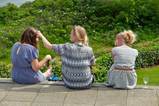 two young women sitting in a park on a sunny  having good time                               