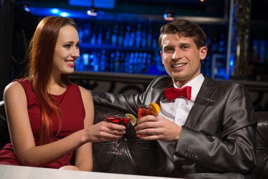 Young couple talking in a nightclub, have fun