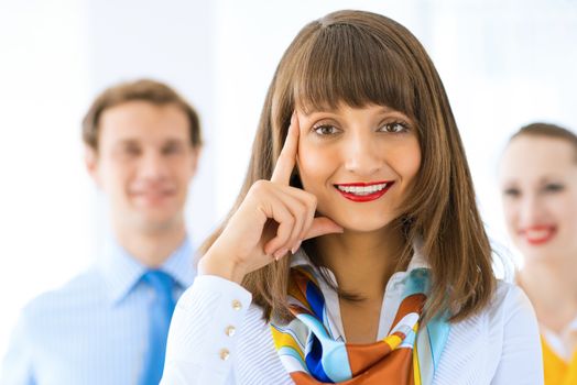 Portrait of a young successful business woman standing against colleagues