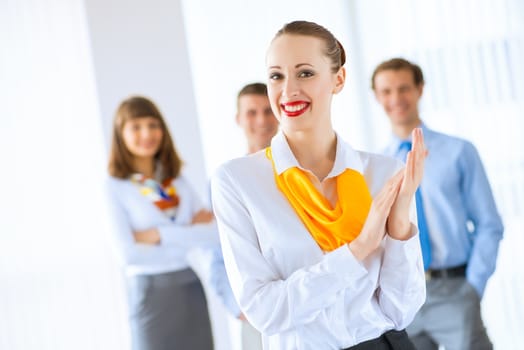 Portrait of a young successful business woman standing against colleagues