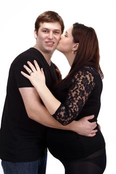 loving happy couple, pregnant woman with her husband, woman kissing her husband isolated on white background