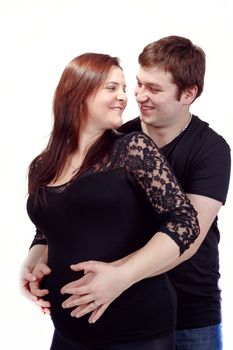 loving happy couple, smiling pregnant woman with her husband, isolated on white background, looking at each other
