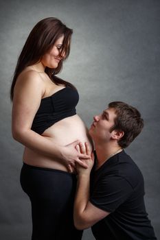 Loving happy couple, pregnant woman with her husband looking at each other