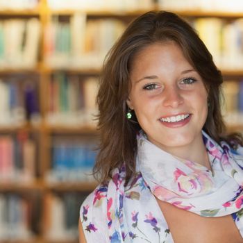 Close up portrait of a smiling female student in the library