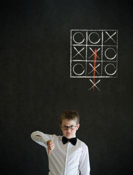 Thumbs down boy dressed up as business man with thinking out of the box tic tac toe concept on blackboard background