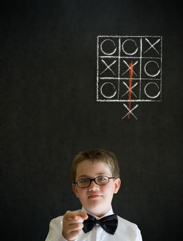 Education needs you thinking boy dressed up as business man with thinking out of the box tic tac toe concept on blackboard background