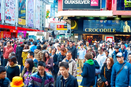 Hong Kong S.A.R. - Jan 19, 2013: Shoppers and visitors crowd at a shopping street on Jan 19, 2013 in Hong Kong. With a land of 1,104 km and population of 7 million, Hong Kong is one of the most densely populated areas in the world