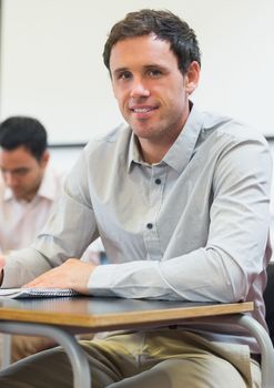 Portrait of a mature student taking notes in lecture in college