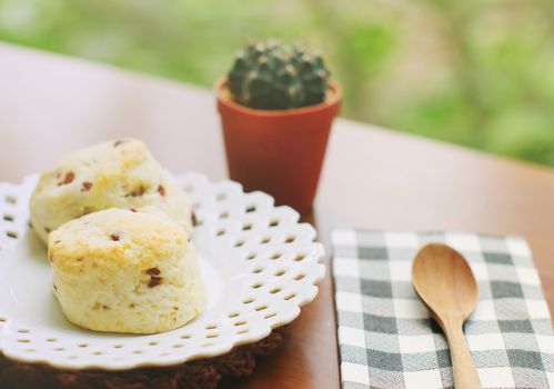 Homemade freshly baked scones with wooden spoon and cactus, retro filter effect