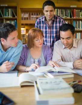 Four mature students studying together in the library