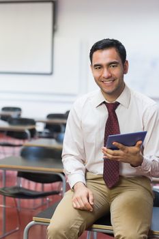Portrait of a smiling teacher with tablet PC in the class room