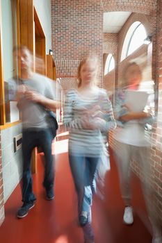 Students walking through hallway toward camera in school