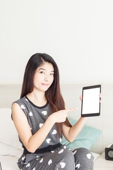 Young woman pointing on tablet