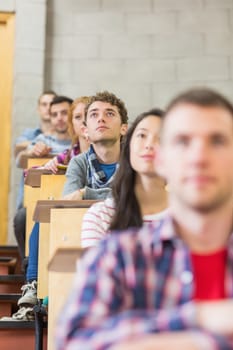 Close up of young students sitting in a row at the college classroom