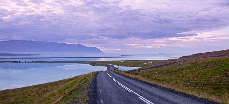 Icelandic landscape. Summer, fjord, sunset, road. Panorama.