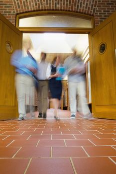 Low angle view of a group of blurred people walking through open doors
